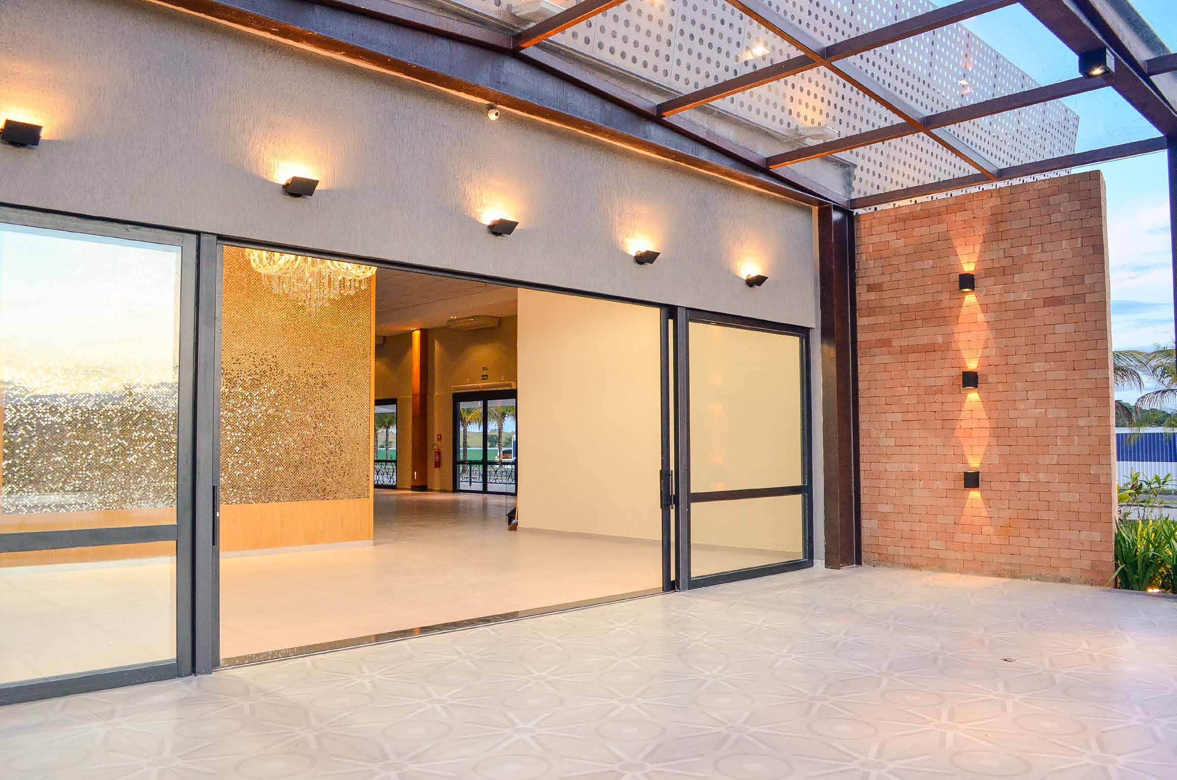Hall do Galpon com painel dourado e lustre de cristal